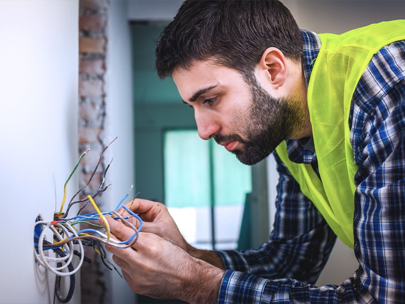 Electrician working inside a residential electrical panel