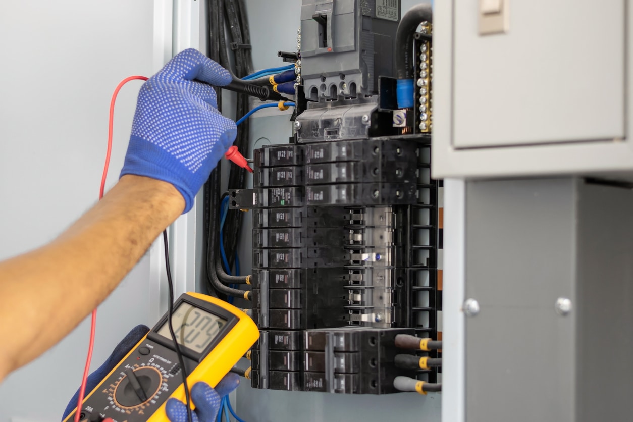 An electrician performs a residential electrical inspection on a fuse box to make sure all circuits are functioning properly.